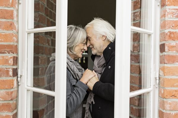 Senior couple face to face by window